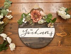 a wooden sign that says the jordans with flowers around it on a wood surface