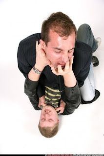 a man is holding his face up to another man's head