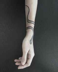 a person's arm with a snake tattoo on it