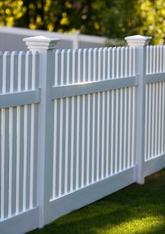 a white picket fence in the grass