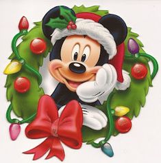 a mickey mouse christmas ornament hanging on a wall in front of a wreath