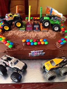 a birthday cake with monster trucks on it