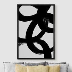 a black and white abstract painting on the wall above a bed with yellow throw pillows