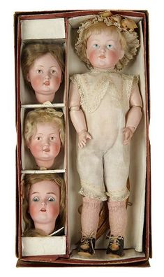 an old doll in a box with four dolls inside