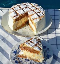 a cake sitting on top of a white plate next to a blue and white table cloth