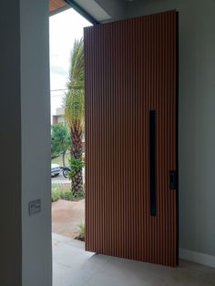 an open door leading to a parking lot with palm trees in the background on a sunny day