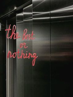 the best or nothing written on glass in front of a black wall with red lettering