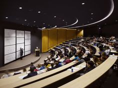 a lecture hall filled with people sitting at desks