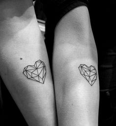 two people with matching tattoos on their arms, one has a heart and the other has a diamond