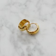 "Brand new. One of our everyday favorites! Made with clean and hypoallergenic 316L titanium. Dainty and simple design. They can be stacked up with any other earrings or ear cuffs. Beautiful gold finish. Material: 18k gold plated titanium and hypoallergenic titanium posts Diameter: 0.55\" / 1.4cm The width of the earring band: 0.27\" / 7mm Weight of one earring: 3.7g Q&A 1. What is the material? - It is made from 18K real gold plated titanium. Titanium is nickel-free, zinc-free and hypoallerg Mini Hoop Earrings, Hypoallergenic Jewelry, Earrings Simple, Ear Cuffs, Domed Ring, Ring Sizer, Real Gold, Gold Finish, Minimalist Fashion