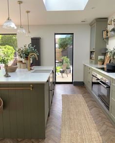 a kitchen with an open door leading to a patio area and outdoor dining room in the background