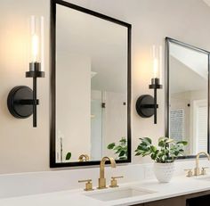 a bathroom with two sinks, mirrors and lights on the wall next to each other