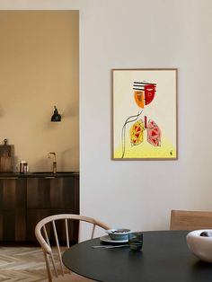 a dining room table with two plates on it and a painting hanging above the table