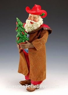 a figurine with a beard and red hat holding a christmas tree in his hand