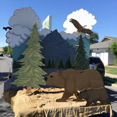 the bear and cub are on display in front of the mountain scene with an eagle