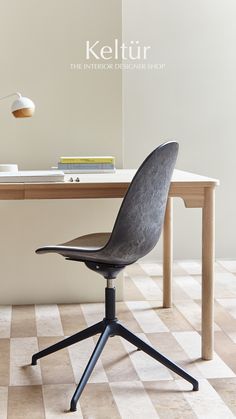 an office chair sitting on top of a checkered floor next to a wooden desk