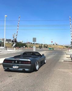 a black sports car parked on the side of an empty street in front of a traffic light