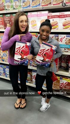 two girls holding up boxes of cereal in a store