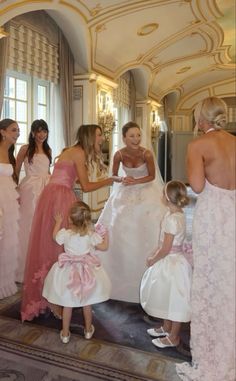 a group of women standing next to each other in front of a mirror on top of a floor