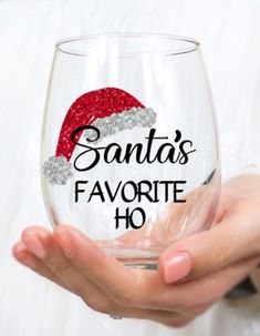 a person holding a wine glass with santa's favorite ho written on it