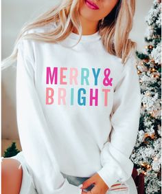 Our Merry & Bright Christmas sweatshirts are so comfy and cozy. They're soft, heavy and warm which makes them perfect for winter. These bright, cheerful sweatshirts make a great gift for mom, friends, family and anyone who loves the holiday season. 50% polyester, 50% cotton Warm and cozy Fits true to size For an oversized look, we recommend ordering up a size or two depending on how big you like it! These shirts are made to order. Unfortunately, we are unable to speed up production times. It may be possible to expedite shipping only for an additional fee. Please message us for more information. Since all of our shirts are made to order, we do not accept returns. However, your satisfaction is incredibly important to us. If you experience any issues with your purchase, please contact us so t Christmas Clothing, Funny Christmas Shirts, Christmas Mom, Cozy Sweatshirts, Holiday Shirts, Christmas Women, Pink Christmas, Christmas Sweatshirts, Merry And Bright