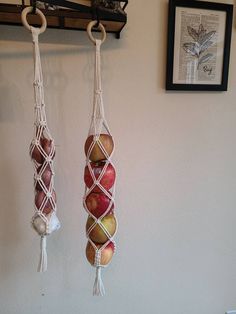 two macaroni and apple hanging from hooks on the wall next to a door