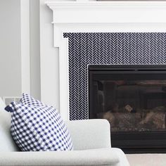 a living room with a white couch and a fireplace in the corner, next to a black and white patterned wall