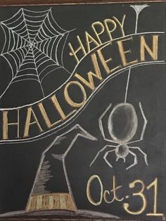 a chalkboard with the words happy halloween written on it and a spider web in front