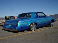 a blue station wagon parked in a parking lot