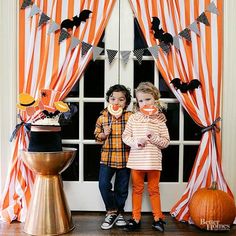 two young children standing in front of a door decorated for halloween