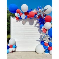 an arch made out of balloons and stars is decorated with red, white, and blue streamers