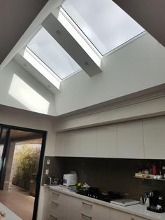 an open kitchen with skylights above the stove and counter top area in front of it