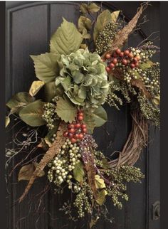 a wreath with berries and green leaves hanging on the front door to welcome people into the house