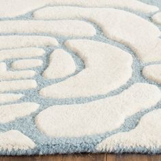 a blue and white rug on top of a wooden floor