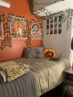 a bed room with a laptop computer on top of it next to a wall covered in pictures