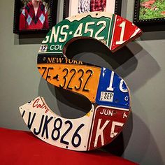 the letter s made out of license plates hangs on the wall next to two framed pictures