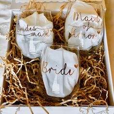 three bridesmaid wine glasses in a box with gold foil writing on them and matching napkins