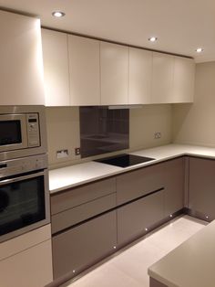 a modern kitchen with white cabinets and stainless steel appliance, including an oven