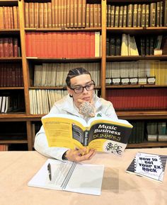 a person sitting at a table with a book in front of them and an open book