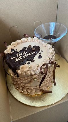 a birthday cake sitting on top of a cardboard box next to a glass bowl with chocolate frosting