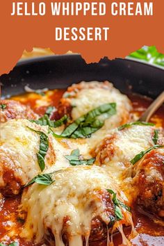 a skillet filled with cheese covered meat and tomato sauce, garnished with fresh basil