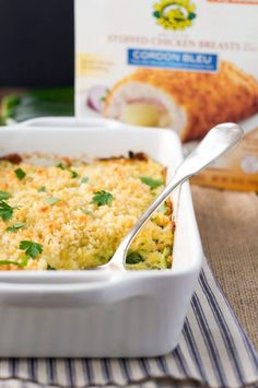 a casserole dish with broccoli, cheese and bread in the background