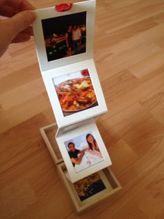 an open box with three pictures inside on a wooden floor