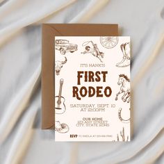 a brown and white first rodeo birthday party card on top of a bed covered in sheets