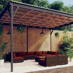 an outdoor living area with couches and potted plants