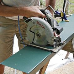 a man using a circular saw to cut wood