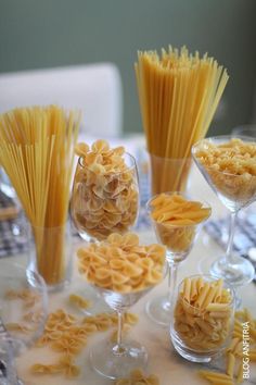 several glasses filled with pasta on top of a table