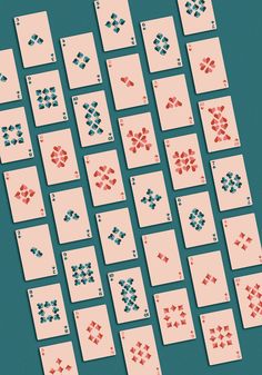 several playing cards are arranged in rows on a blue surface with red, white and blue dots