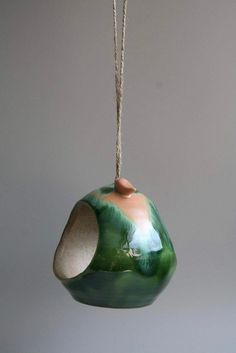 a ceramic bird feeder hanging from a rope