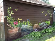 a painting on the side of a building with flowers and rocks painted on it's sides